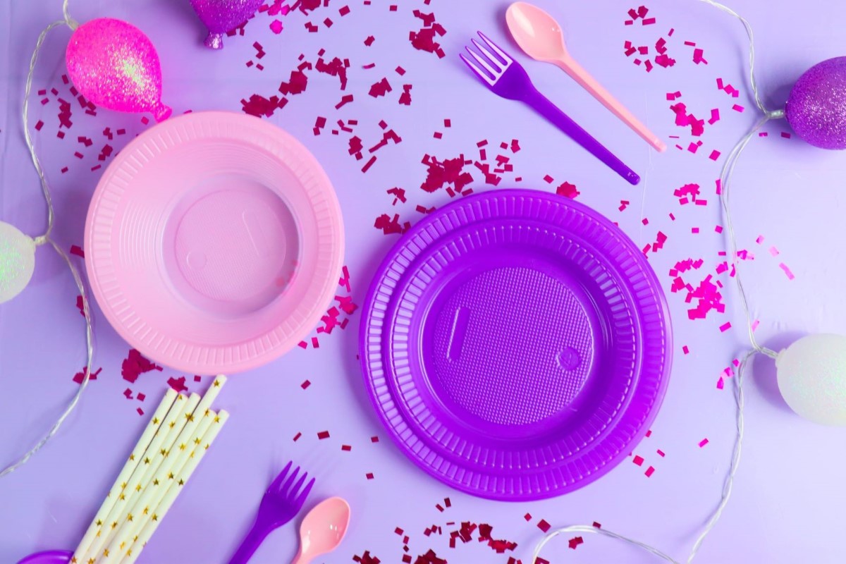 Copos, talhares e pratos descartáveis e canudos com tons de roxo e rosa. Produtos Bello Festas.